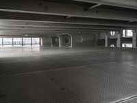 an empty parking garage with a metal floor and a clock on the wall above the doorway