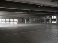 an empty parking garage with a metal floor and a clock on the wall above the doorway