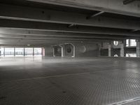 an empty parking garage with a metal floor and a clock on the wall above the doorway