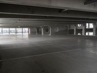 an empty parking garage with a metal floor and a clock on the wall above the doorway