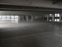 an empty parking garage with a metal floor and a clock on the wall above the doorway