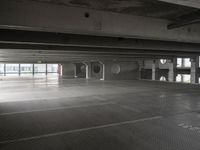 an empty parking garage with a metal floor and a clock on the wall above the doorway