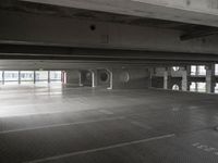 an empty parking garage with a metal floor and a clock on the wall above the doorway