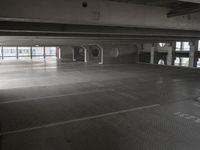 an empty parking garage with a metal floor and a clock on the wall above the doorway