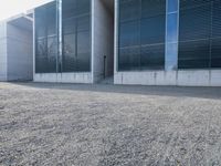 the black skateboard is in front of a tall building with lots of windows and concrete