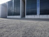 the black skateboard is in front of a tall building with lots of windows and concrete