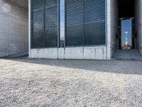 the black skateboard is in front of a tall building with lots of windows and concrete
