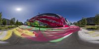 an outdoor area with a multicolored skateboard park in the center of it