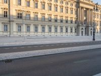 there is an empty street with a red bus next to the building on the side