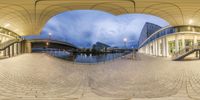 a fisheye lens captures a reflection of a city street and a bridge with buildings