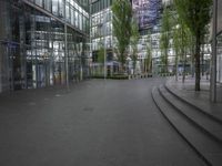 a walkway through a park with trees in the background at night time in front of an office building