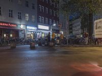 a water fountain gusging through the streets by buildings at night on a city street