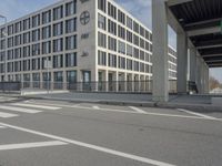 the empty parking lot in front of an office building next to a highway has been painted with lines on it