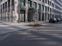 empty street with a tree branch next to an office building with a water spout and ladder in it