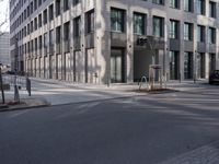 empty street with a tree branch next to an office building with a water spout and ladder in it