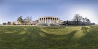 a circular picture of an ornate building in a park on a sunny day with a circular lens