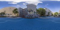 the upside down view of an outdoor basketball court and buildings with street art on it