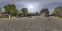 a 360 - vr of a park with trees, benches and a building in the background