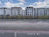 an empty parking lot in front of a group of apartment blocks with the number 36 on it