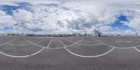 the view of a parking lot with airplanes in the background on a cloudy day by some clouds