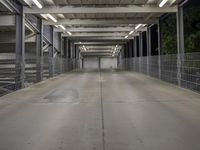 a very long empty pedestrian bridge at night with no lights on it's sides