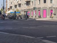 there is a pink building on the corner of this street, with a bicycle rack in the middle