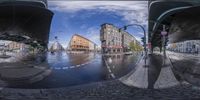 a very empty city street is pictured through a fish eye lens on a rainy day