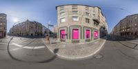 a large building has pink lights at the bottom of the building in a 360 - angle lens