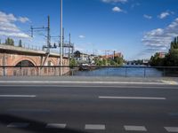 a road and bridge with a river in the distance and buildings across from it in front and on either side