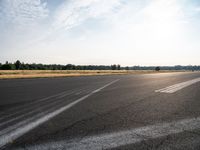 a road with pavement and the sunlight coming down over it to the right of it