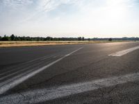 a road with pavement and the sunlight coming down over it to the right of it