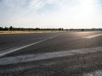 a road with pavement and the sunlight coming down over it to the right of it