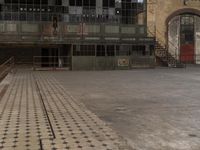 an empty brick floor has a cross pattern on it and a person standing in the doorway