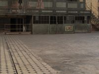 an empty brick floor has a cross pattern on it and a person standing in the doorway