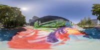 a view of a half pipe with graffiti on it at a skate park in a city