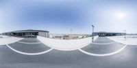 skateboarders are on skateboards in an empty skate park area, viewed from a large 360 - lens