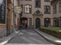 an empty cobblestone street is shown in the early evening sunshine in this urban setting