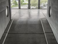 a couple of cement steps leading up to a floor that has a bunch of window with lots of glass on top