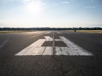 the sun is setting on an airport runway with the runway and airplane taxiway marked