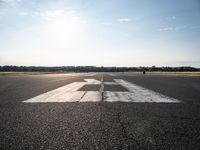 the sun is setting on an airport runway with the runway and airplane taxiway marked