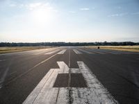 the sun is setting on an airport runway with the runway and airplane taxiway marked