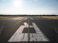 the sun is setting on an airport runway with the runway and airplane taxiway marked