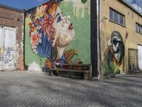 the street is painted with murals of women and birdies and a man on the bench