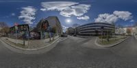 a 360 - view panoramic of a street in front of a building and a tall building with graffiti on it