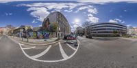 a fish - eye lens picture shows a street with graffiti and buildings on both sides