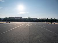 an empty parking lot with many people in it and on bicycles on the pavement nearby