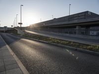 the sun is setting behind the roadway and cars are on the road at dusk or night