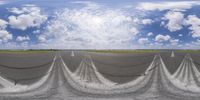 a tarmac next to the runway on a cloudy day as clouds are low overhead