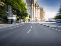 a city street with trees on both sides and the building behind it, blurred with light