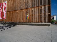 a group of people riding skateboards near wooden panels and stairss with artwork on them